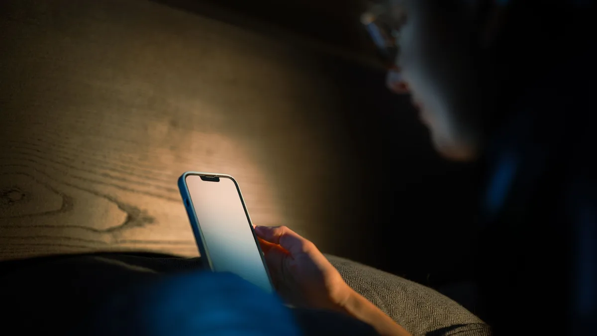 person scrollt nachts allein im bett durchs handy