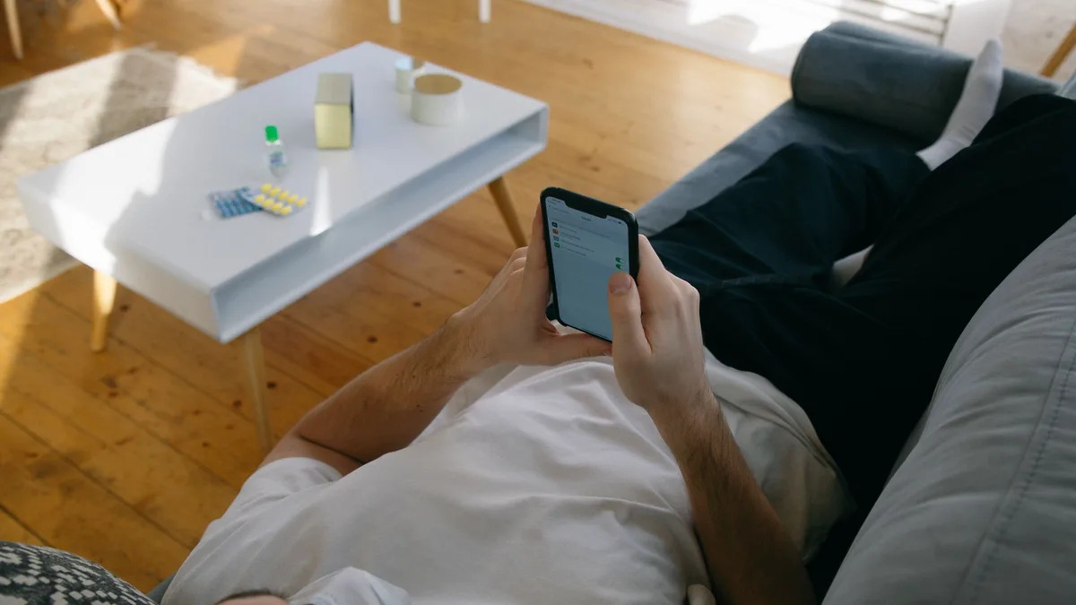 person liest entspannt nachrichten auf dem sofa