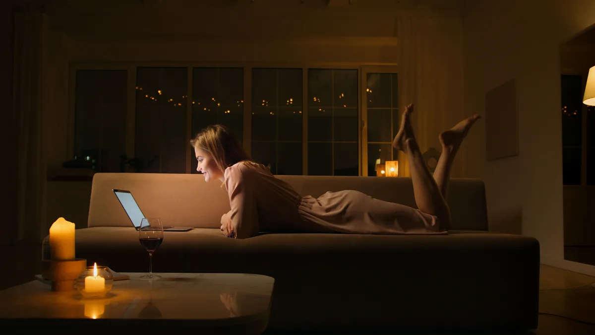 frau lächelt beim online dating am laptop