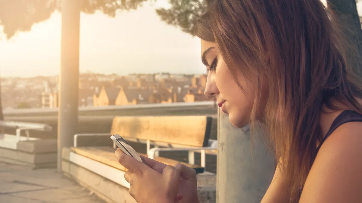 Frau tippt konzentriert eine Nachricht in ihr Smartphone